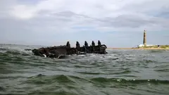Faro de José Ignacio y restos de un naufragio sobre la costa rocosa.